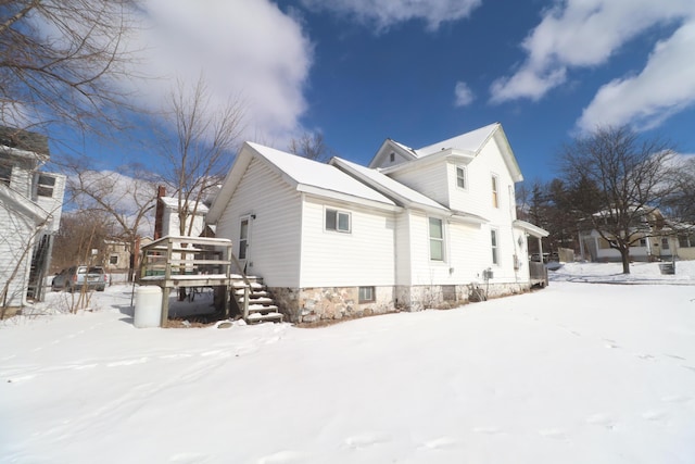 view of snow covered exterior featuring a wooden deck