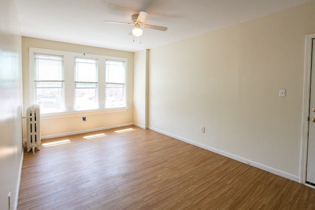 spare room with ceiling fan, baseboards, and wood finished floors