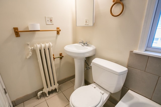 bathroom with toilet, radiator heating unit, baseboards, and tile patterned floors