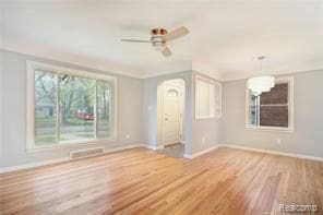 unfurnished living room with visible vents, ceiling fan, baseboards, and wood finished floors