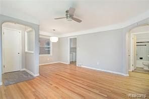 spare room featuring ceiling fan, wood finished floors, and baseboards