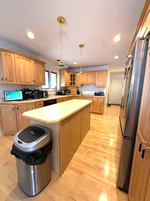 kitchen featuring a kitchen island, light countertops, light wood-type flooring, freestanding refrigerator, and glass insert cabinets