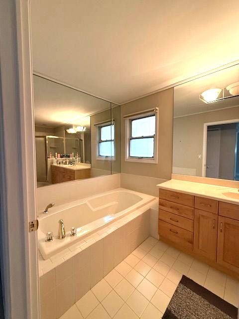 bathroom with a shower stall, a garden tub, vanity, and tile patterned floors