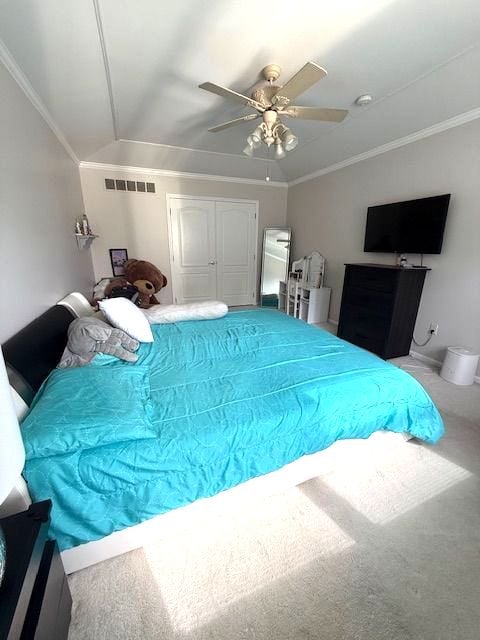 bedroom with visible vents, ceiling fan, vaulted ceiling, crown molding, and carpet flooring