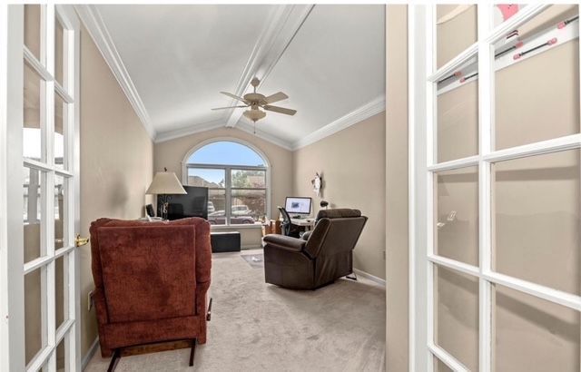 sitting room featuring lofted ceiling, ceiling fan, carpet floors, ornamental molding, and french doors