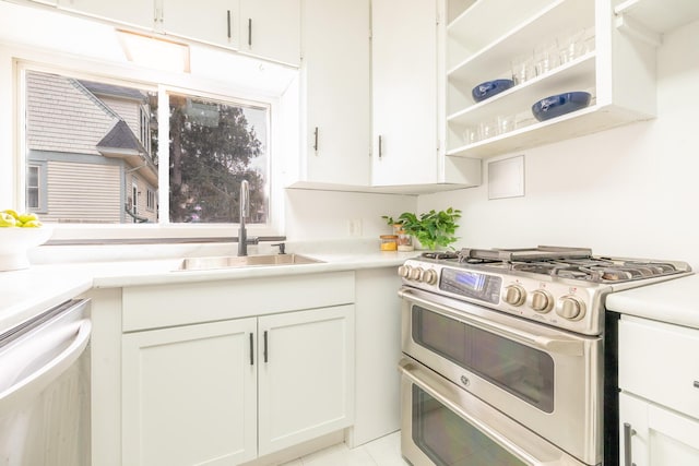 kitchen featuring light countertops, appliances with stainless steel finishes, a sink, and white cabinetry