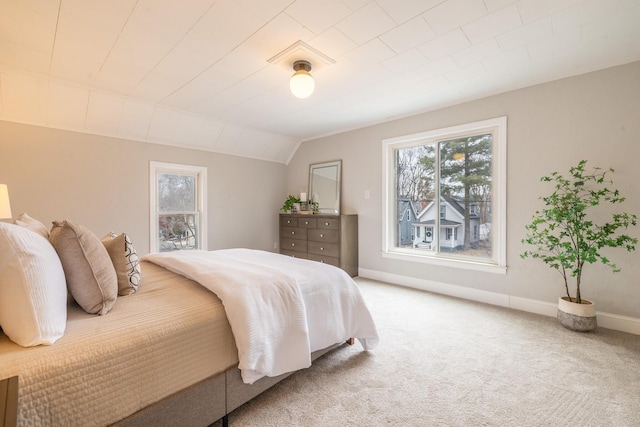 bedroom with vaulted ceiling, carpet floors, and baseboards