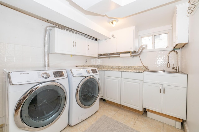 laundry room featuring cabinet space, a sink, washing machine and clothes dryer, and light tile patterned flooring