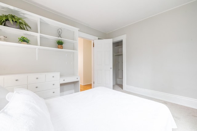 bedroom with light carpet and baseboards