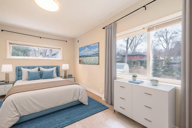 bedroom with multiple windows and light wood-type flooring