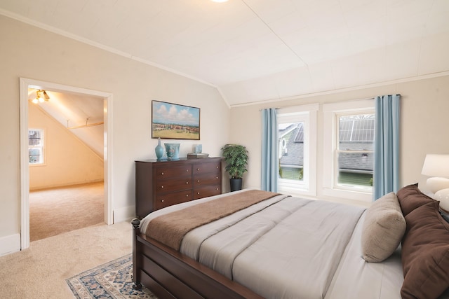 bedroom with carpet floors, baseboards, ornamental molding, and vaulted ceiling