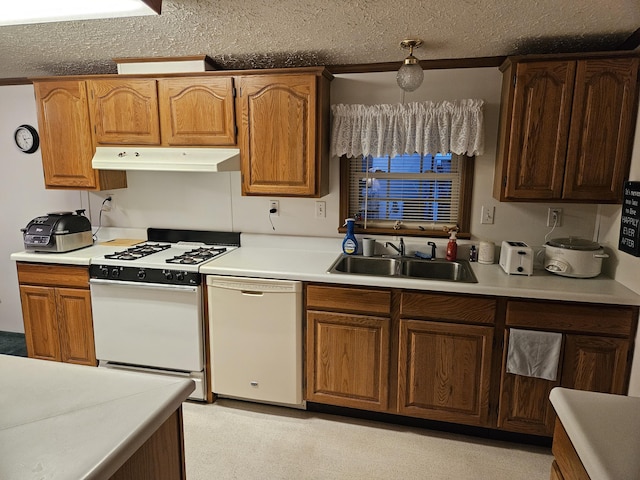 kitchen featuring light countertops, a sink, a textured ceiling, white appliances, and under cabinet range hood