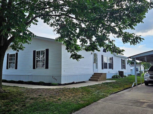 manufactured / mobile home featuring entry steps, central air condition unit, and a front lawn