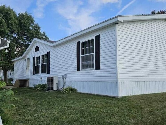 view of side of property featuring a lawn and central air condition unit