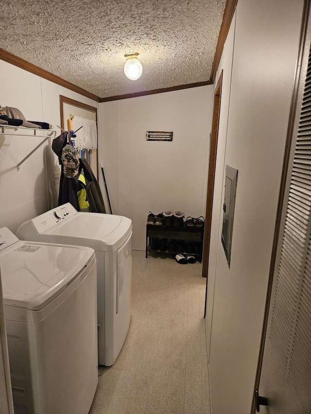 clothes washing area featuring ornamental molding, laundry area, washer and clothes dryer, and a textured ceiling