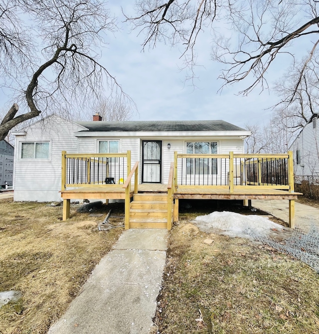 rear view of property with a chimney and a wooden deck