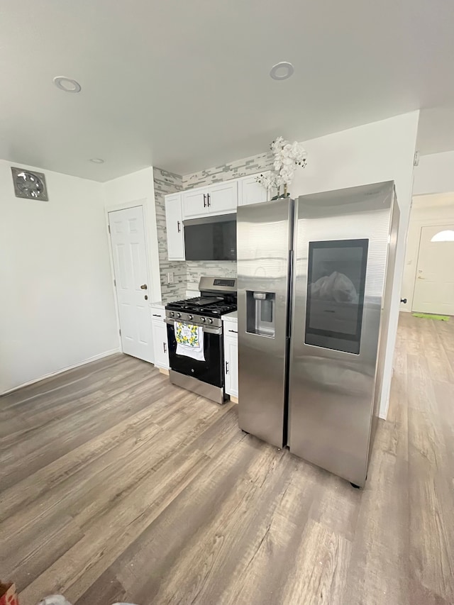 4539 Trumbull Dr, Flint, MI 48504 - kitchen with stainless steel appliances, light wood-style floors, backsplash, white cabinetry, and light countertops
