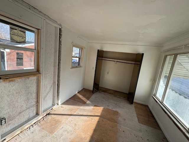 interior space featuring a closet and baseboards