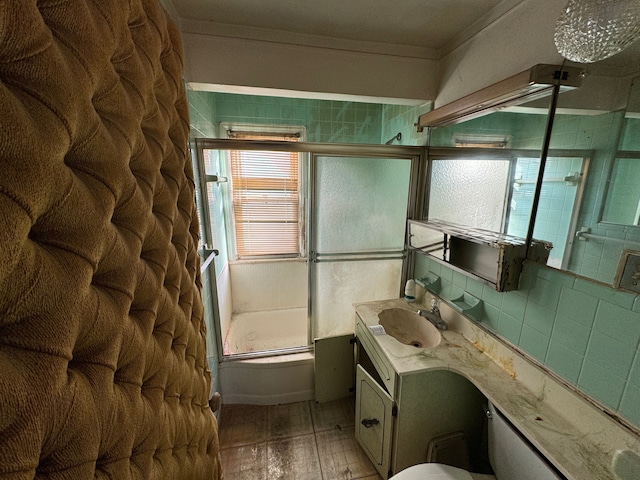 bathroom featuring shower / bath combination with glass door, crown molding, and vanity