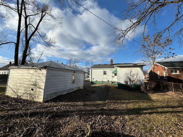 rear view of house featuring an outbuilding