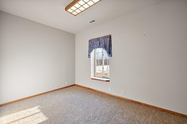 spare room featuring carpet flooring, visible vents, and baseboards