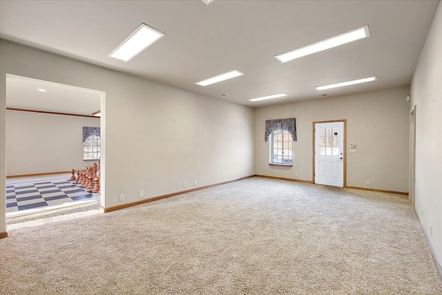 carpeted spare room featuring baseboards