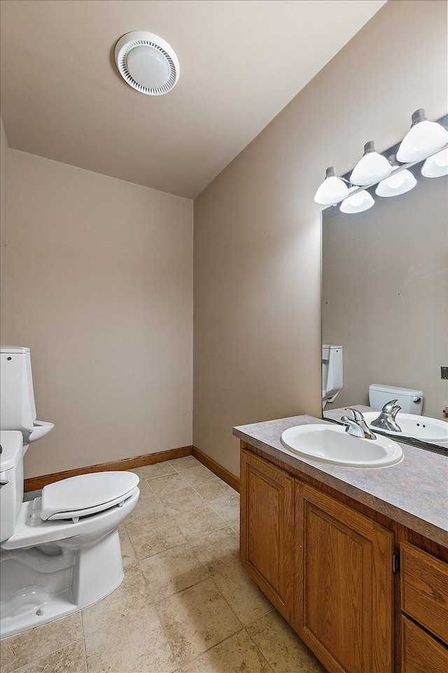 half bath with toilet, baseboards, visible vents, and vanity