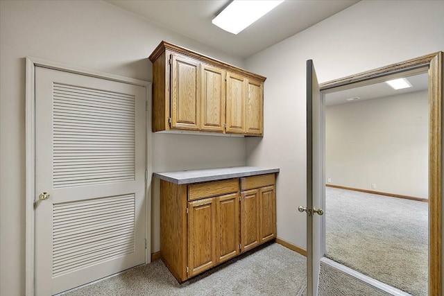 interior space featuring light carpet and baseboards