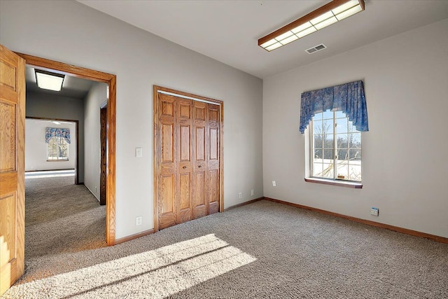 unfurnished bedroom with baseboards, a closet, visible vents, and carpet flooring