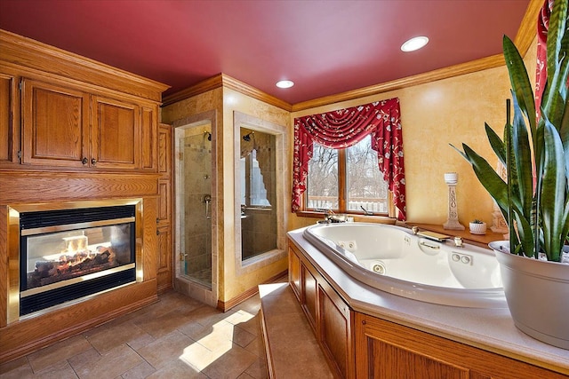 full bath with ornamental molding, a jetted tub, a shower stall, and a glass covered fireplace