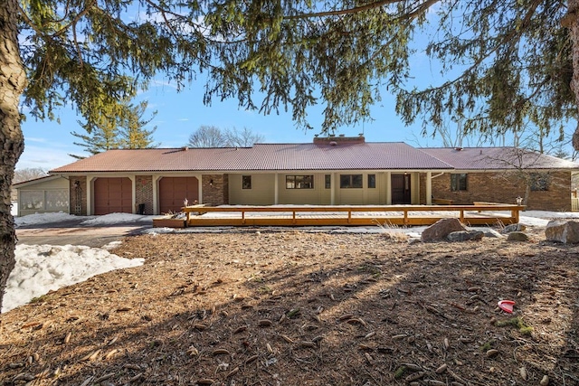 ranch-style home with a garage, brick siding, and a tile roof