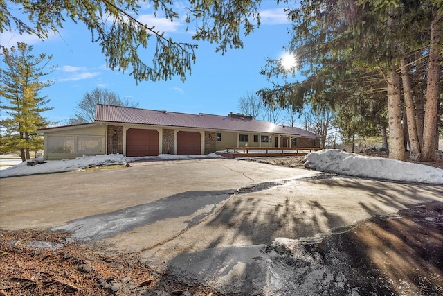 single story home with a garage, brick siding, and driveway