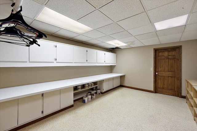 unfurnished office with baseboards and a drop ceiling