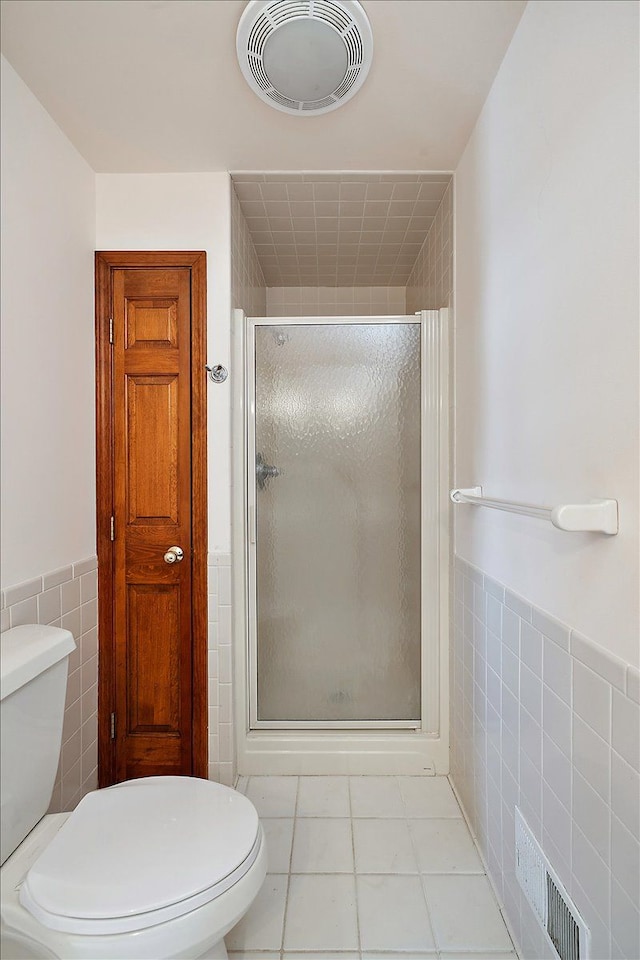 full bath featuring toilet, visible vents, and tile walls