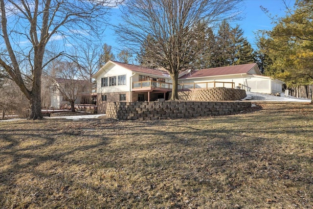 rear view of house featuring brick siding and a yard