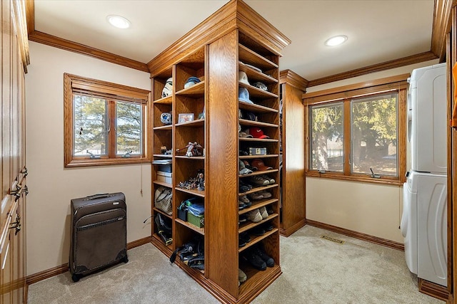 walk in closet featuring light carpet and stacked washer and dryer