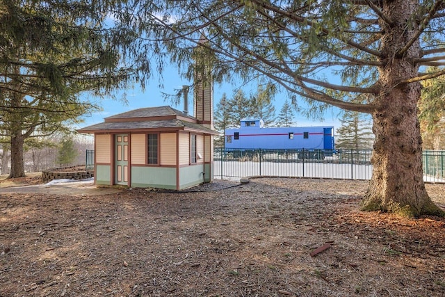 exterior space with fence, a chimney, and an outdoor structure