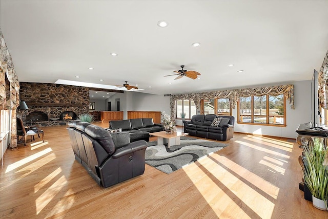 living area with recessed lighting, a fireplace, light wood-style flooring, and ceiling fan