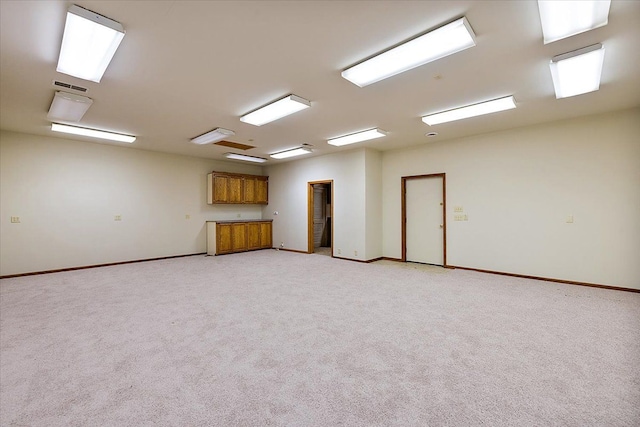 empty room featuring light carpet, visible vents, and baseboards