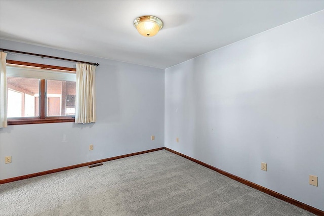 spare room with visible vents, baseboards, and carpet flooring