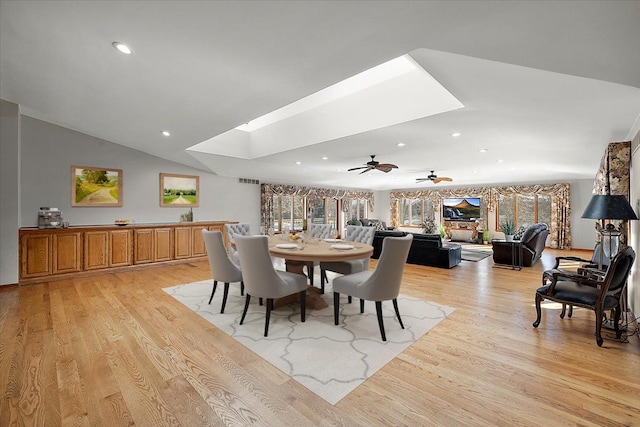 dining area featuring lofted ceiling with skylight, light wood-type flooring, visible vents, and recessed lighting