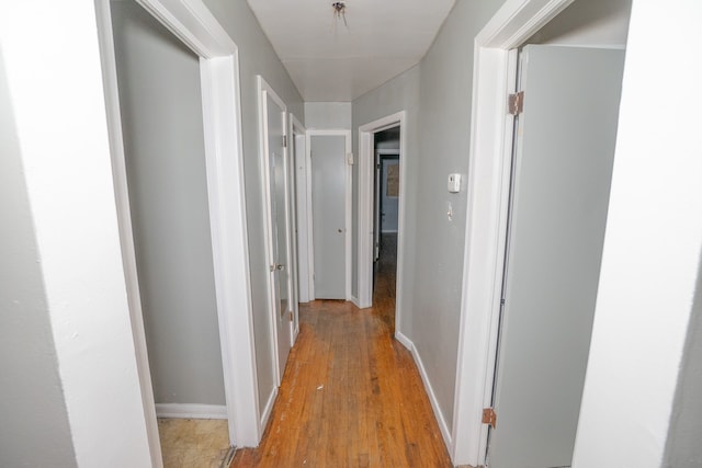 hallway with light wood-style flooring and baseboards