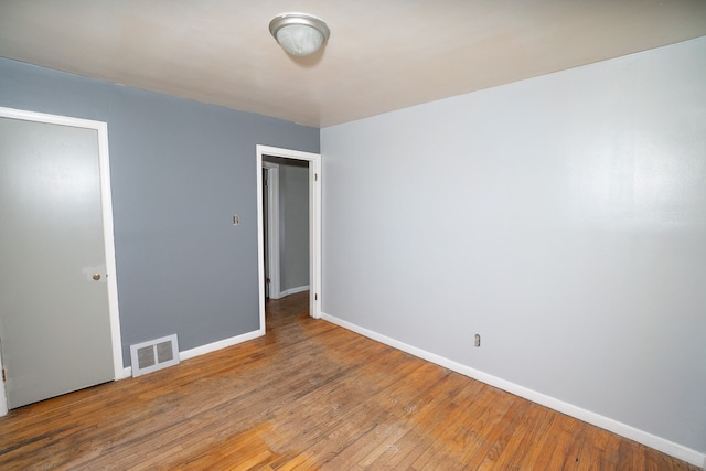 unfurnished bedroom with baseboards, visible vents, and hardwood / wood-style floors