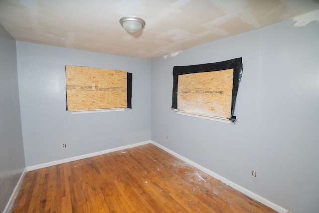 unfurnished room with wood-type flooring and baseboards