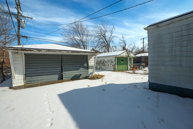 snowy yard featuring an outbuilding