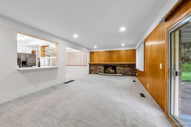 unfurnished living room with carpet, a fireplace, visible vents, and recessed lighting