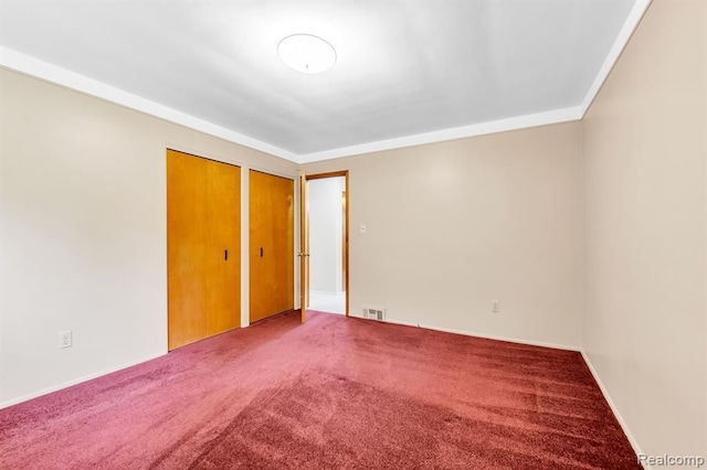 carpeted empty room featuring visible vents