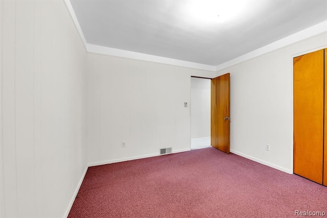 unfurnished room featuring carpet, visible vents, and baseboards