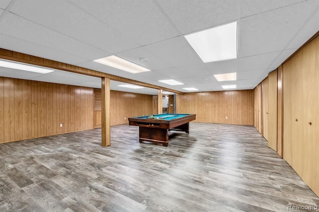 recreation room with a paneled ceiling, wood walls, wood finished floors, and pool table