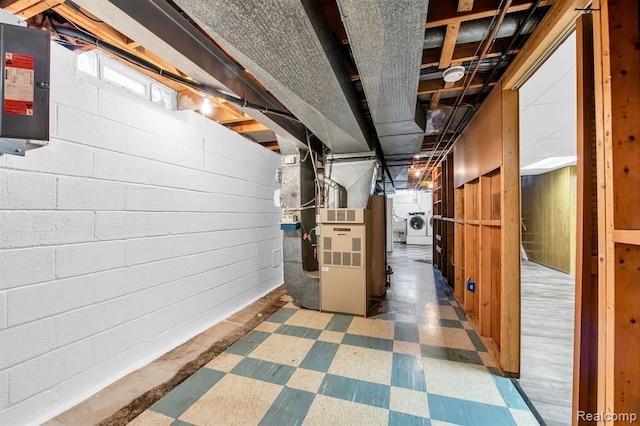 below grade area featuring heating unit, washer / clothes dryer, and tile patterned floors